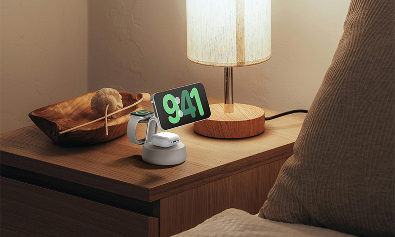 Zdjęcie przedstawia ładowarkę indukcyjną Qi2 25W 3w1 oraz kobietę śpiącą w tyle